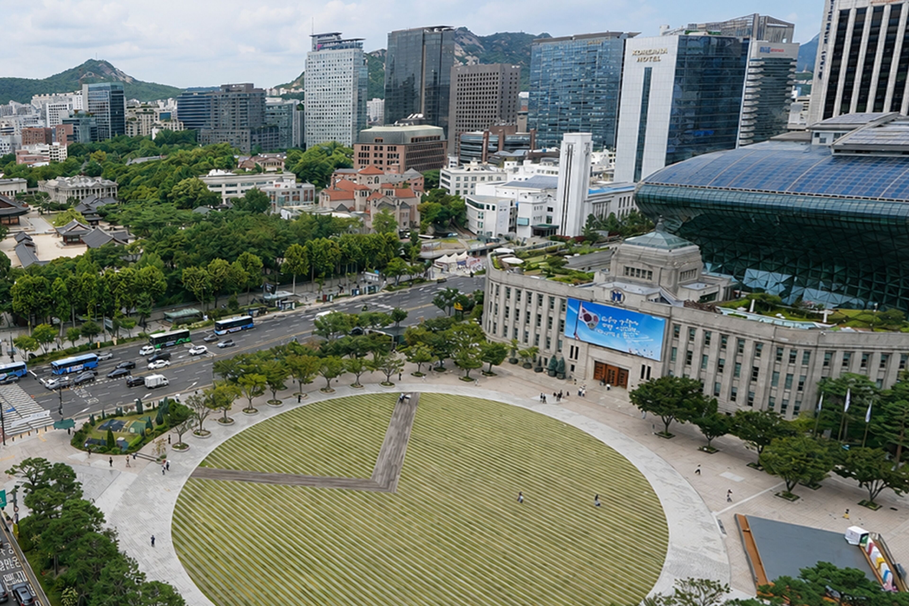 A cityscape with a large circular park surrounded by buildings, including a prominent hotel with a blue sign.
