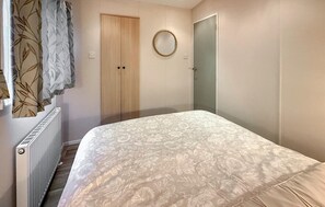 A bedroom with a bed, a radiator, a wardrobe, and a mirror. - Cozy home in Sint Kruis with WiFi (Sint Kruis)