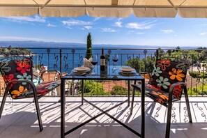 A terrace with a table set for two, overlooking a scenic view of the sea and mountains. - Beachside Villa Mia Apartment 2, Medveja, Croatia (Medveja)