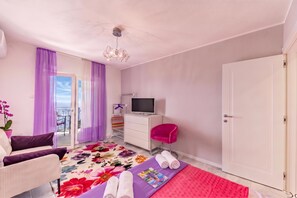 A bedroom with a bed, a TV, a chair, a dresser, and a door. - Beachside Villa Mia Apartment 2, Medveja, Croatia (Medveja)