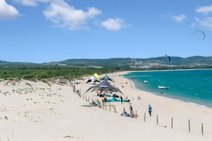 A beach with tents, a fence, and a clear sky. - Elicriso, San Pasquale, Italy (San Pasquale)