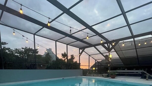 Ein Hallenbad mit freiem Blick auf den Himmel durch eine Stahlkonstruktion.