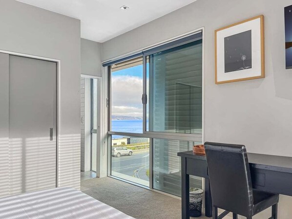 A modern room with a large window, a desk, and a chair.