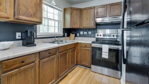 Una cocina con armarios de madera, un refrigerador de acero inoxidable y un horno empotrado.