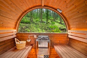 Una sauna con paredes de madera, un banco, un cubo y una camilla.