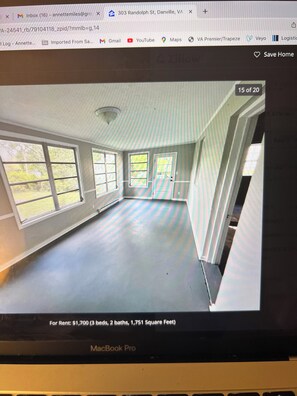 A room with large windows, a sloped ceiling, and a view of greenery outside.