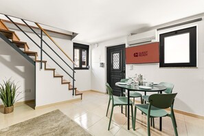 A modern kitchen with a dining area, a staircase, and a 'GUEST READY' sign. - GuestReady - Courtyar 9/99 - Apt 06 (Porto)