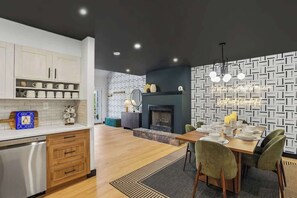 A modern kitchen with white cabinets, a dining area with a table set for four, and a fireplace. - CanaanValley Views! FirePit - Arcade - ResortAmenities (Davis)