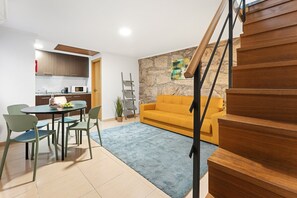Ein zeitgemäßer Wohnraum mit Küche, Essbereich und einer Treppe.