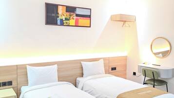 A hotel room with two beds, a desk, a chair, a lamp, a mirror, and a painting on the wall.