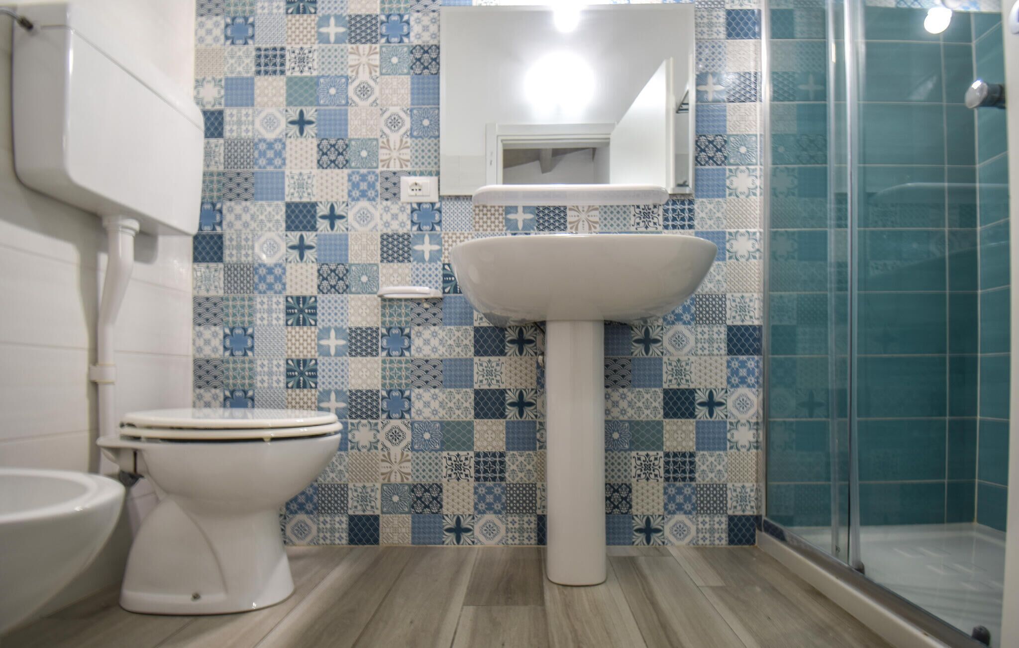 Un baño con inodoro, lavabo y zona de ducha.