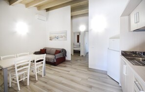 Eine kleine Küche mit Essbereich, einem Sofa und einem Bild an der Wand.