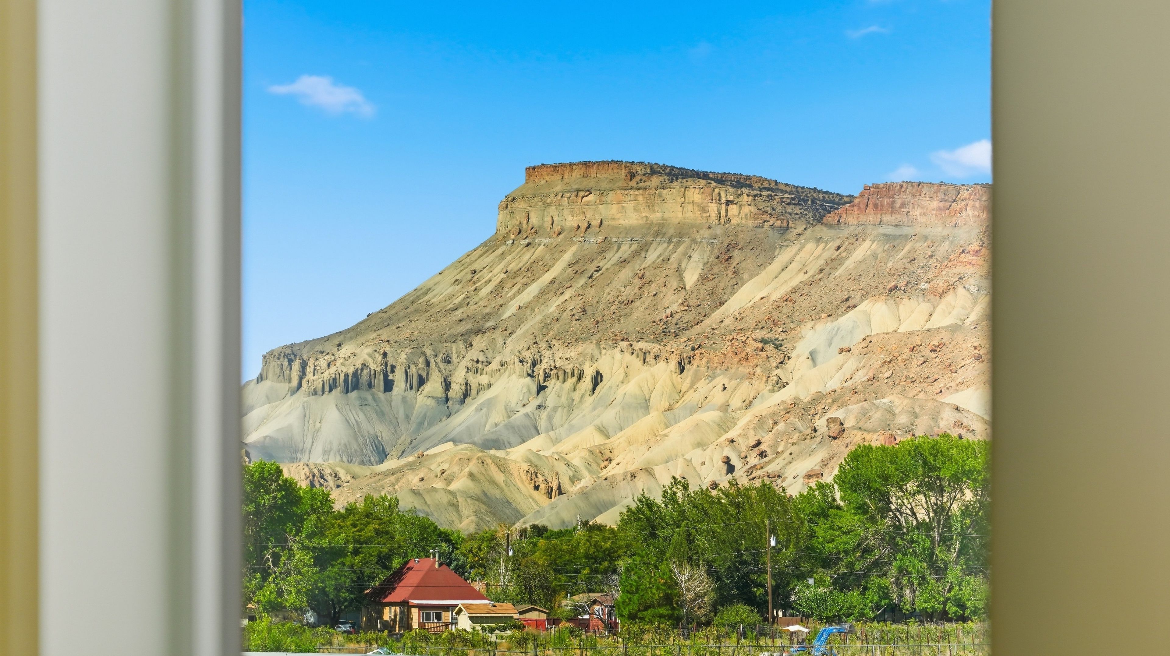A mountain with a flat top and a residential area at its base.