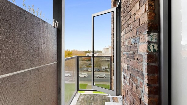 A narrow balcony with a view of a parking lot and buildings. - Serenity Cloud Apartment in Vibrant Footscray (Footscray)