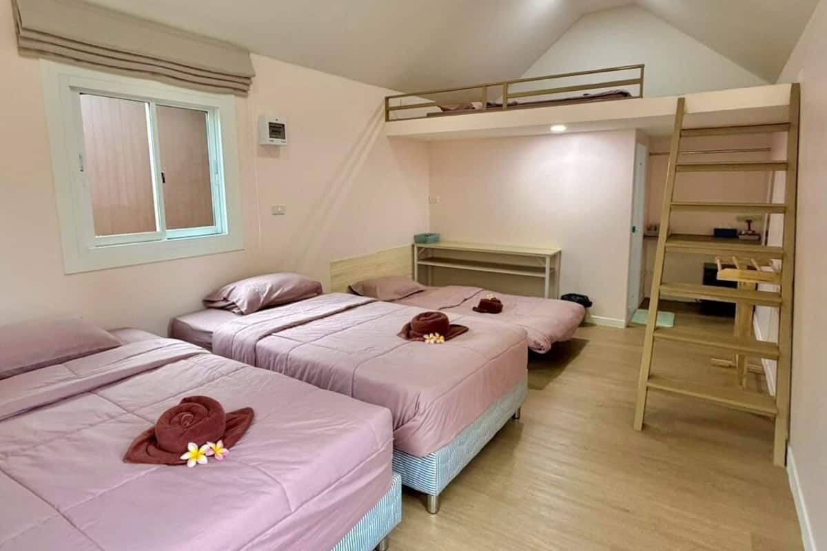 A room with three beds, a bunk bed, a window, and a wooden ladder.