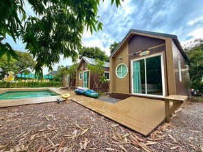 Ein Bungalow mit Pool, Terrasse und kleinem Garten.