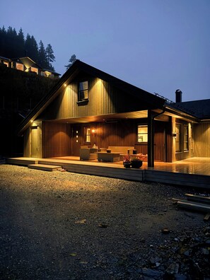 Ein Holzhaus mit Veranda, Kamin und Blick auf die umliegende Landschaft.