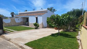 Une maison avec une allée pavée, une petite pelouse et un mur en pierre.