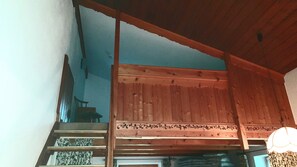 Eine Holztreppe mit Geländer, einem Stuhl und einer Wand mit Muster.