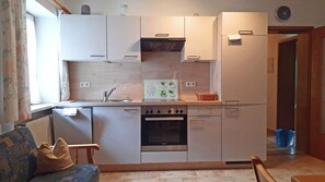Eine kompakte Küche mit Backofen von Siemens, einer Spüle und einer kleinen Arbeitsfläche.