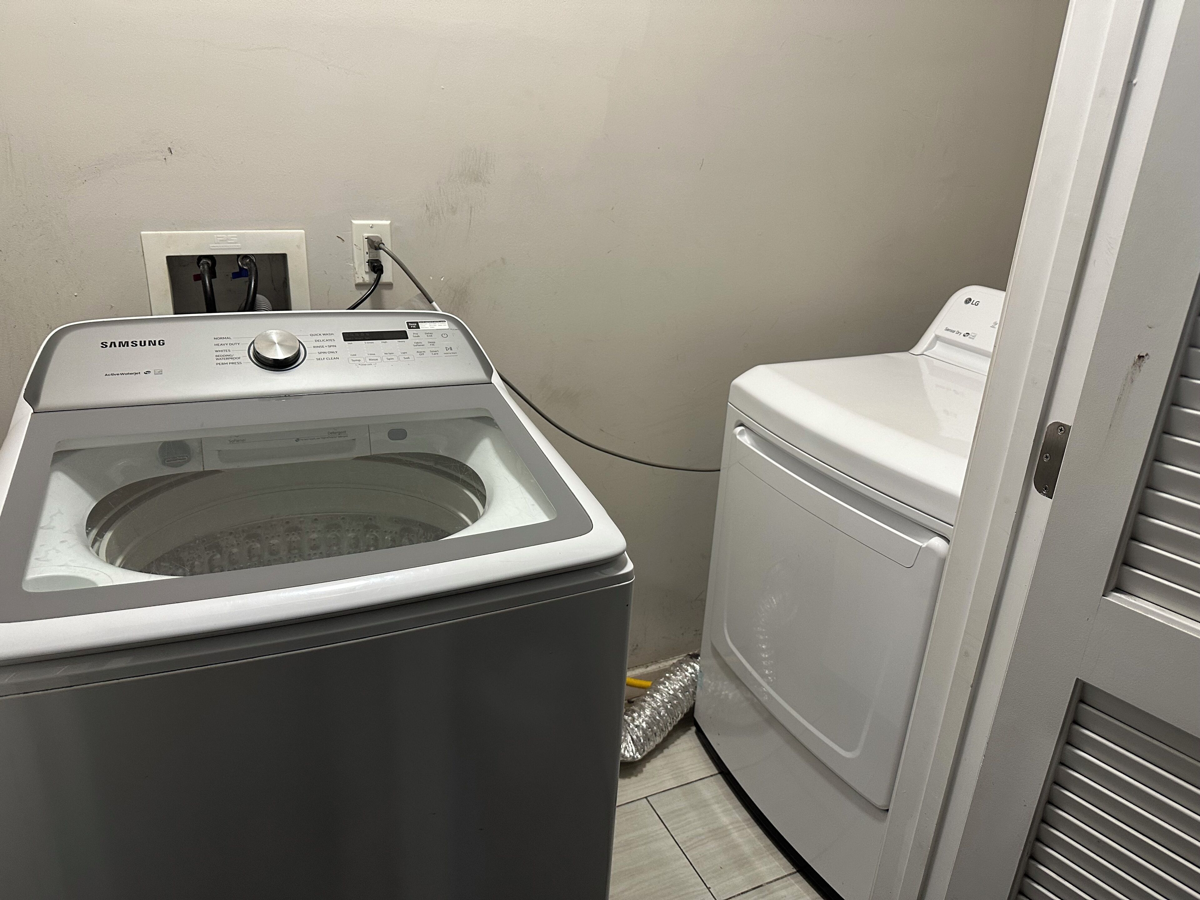 A laundry area with a Samsung washer and dryer, a power outlet, and a vented dryer.