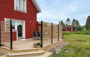A red wooden house with a porch, a door, and a window. - Gorgeous home in Djurås with WiFi (Djurås)