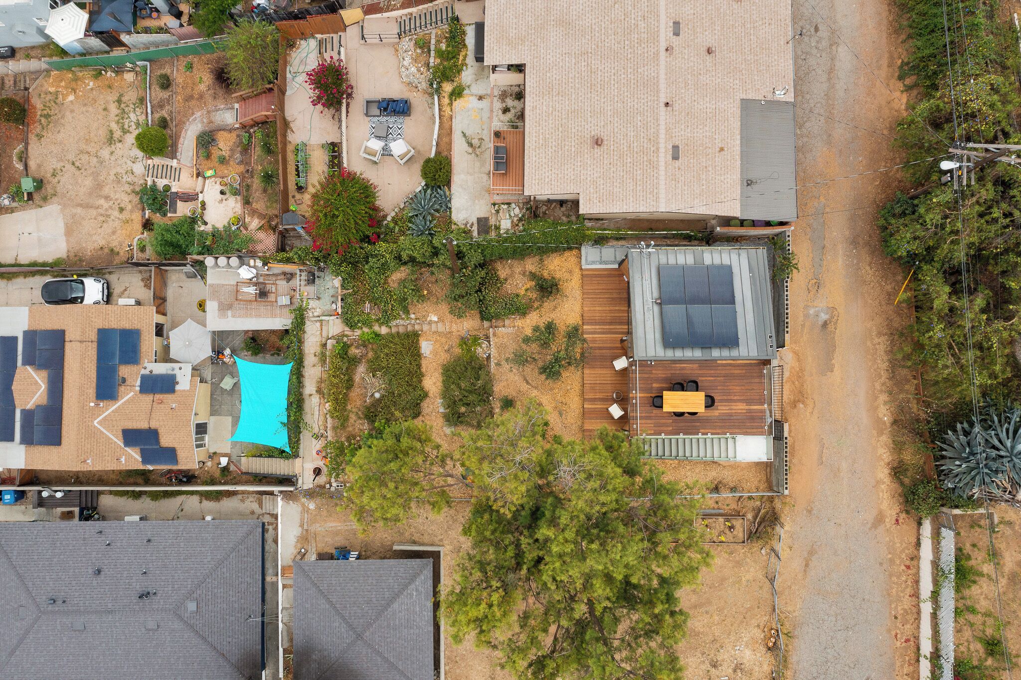 Vue aérienne d’un quartier résidentiel, avec une maison dotée d’une piscine, d’une terrasse et d’une grande fenêtre.