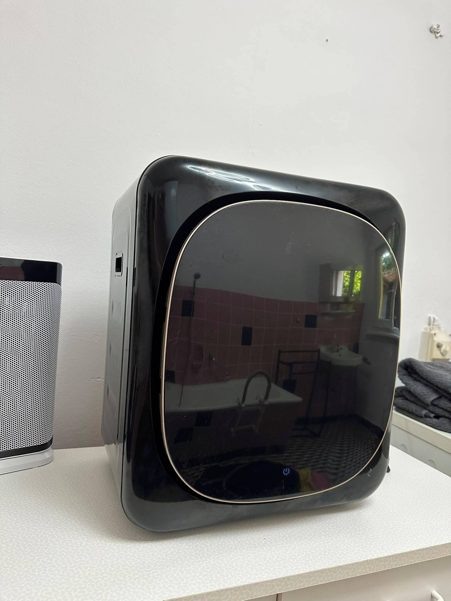 Een zwarte, vintage televisie op een witte ondergrond.