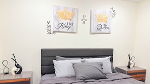 Une chambre à coucher comprenant un lit, deux tables de chevet et deux éléments de décoration murale.