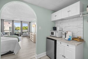A modern kitchen with white cabinets, a dishwasher, and a microwave. - NEW Remodel-Private Balcony-Elevator-Pool-King bed (Myrtle Beach)