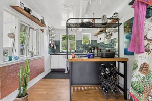 A kitchen with wooden cabinets, a wine rack, and a window with a view of greenery.