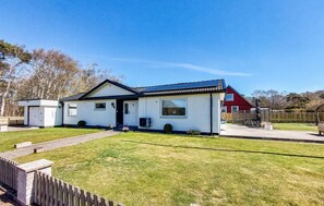A single-story house with a front porch, a garage, and a small attached shed. - 4 bedroom cozy home in Mellbystrand (Mellbystrand)