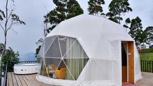 A dome-shaped tent with a window, a door, and a small table with cushions. - Hillside Escape Glamping (Kodaikanal)