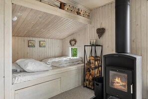Ein gemütliches Zimmer mit einem Bett, einem Kamin und einem Fenster.