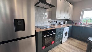 Una cocina moderna con electrodomésticos de acero inoxidable, horno empotrado y lavavajillas.