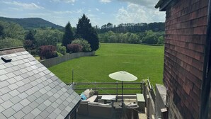 Terraza en la azotea con vistas a un campo verde y árboles.