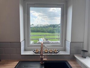 A kitchen with a window view of a green field and trees. - Peak District Cottage near Hope Station (Hope)