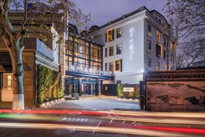 A hotel entrance with a modern facade, large windows, and a sign indicating it is the Crystal hotel. - Crystal Hotel Hangzhou Xihu (Hangzhou)