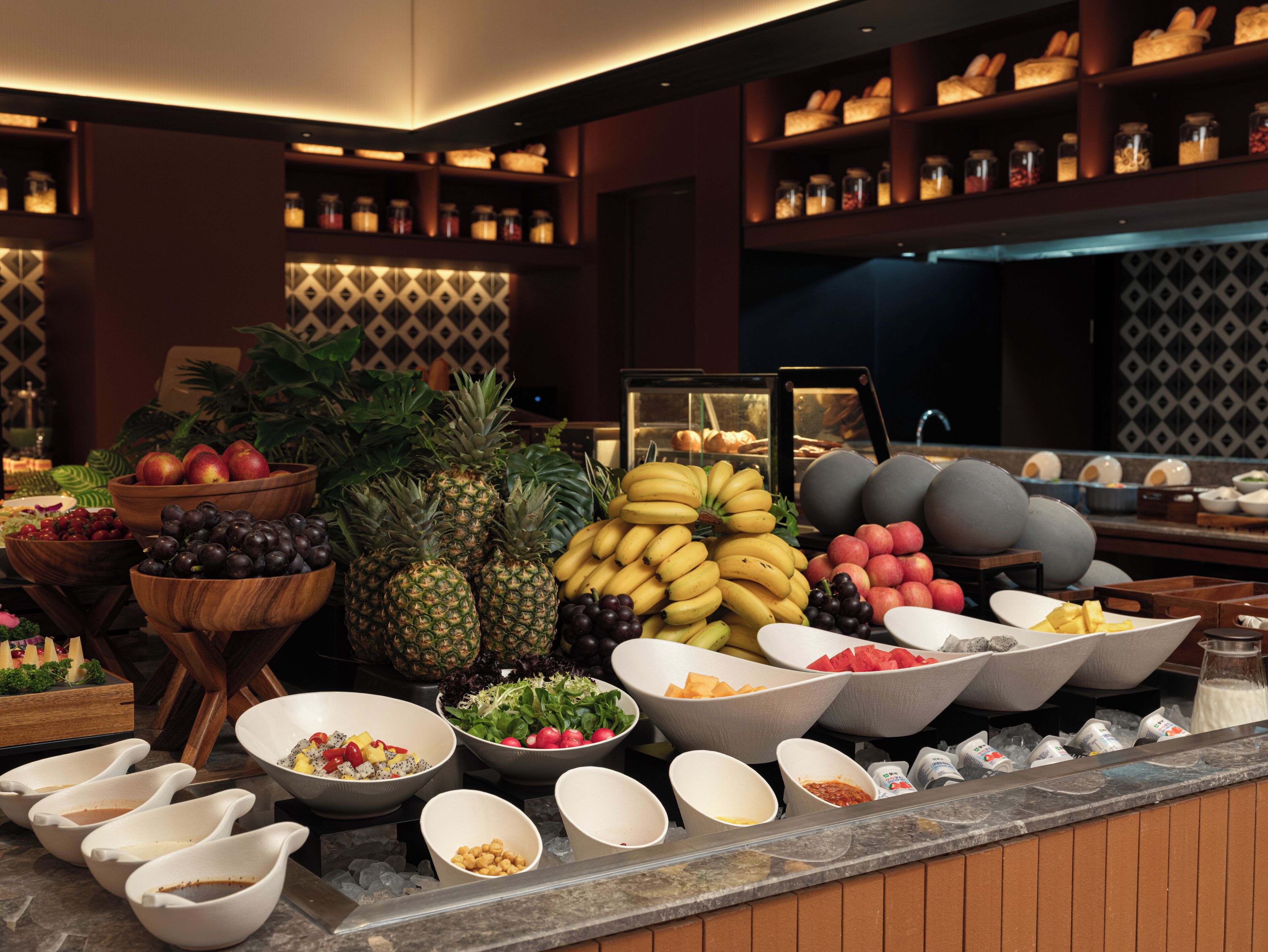 A buffet with various fruits, vegetables, and prepared dishes.