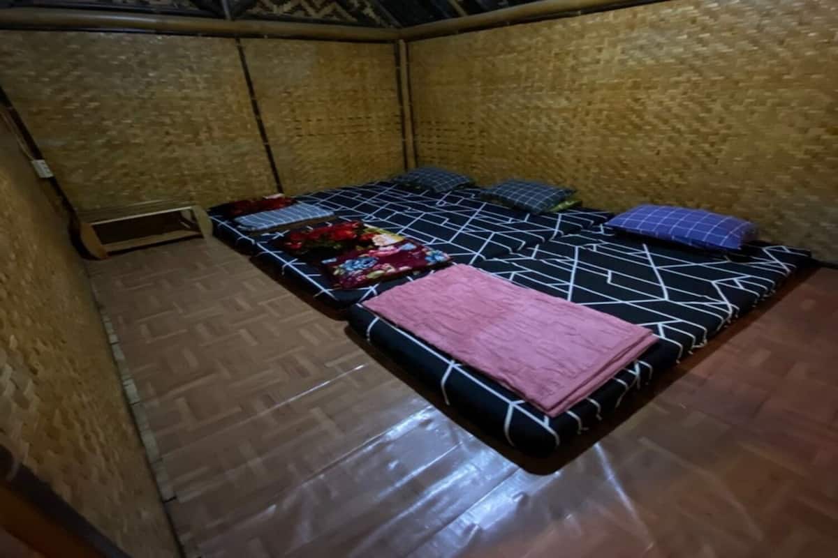 A room with a bed, a small table, and a patterned ceiling.