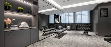 A modern gym with exercise equipment, a mirror, and a large window.