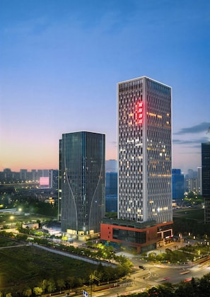 Two high-rise buildings with modern architecture, surrounded by greenery and urban infrastructure. - Intercity Hotel Hangzhou Olympic Expo (Hangzhou)