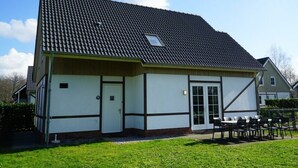 Un bâtiment doté d’un toit recouvert de tuiles, d’une porte et d’une fenêtre.