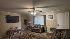 A living room with a ceiling fan, a television, a patterned rug, and two couches. - Vintage- Getaway Fabulous 3-bedroom house with AC in charming Columbus (Columbus)