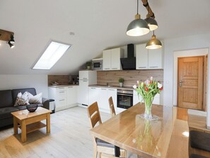 A modern kitchen with white cabinets, a wooden countertop, and a skylight. - Vacation Rental with Panoramic View, Sleeps Up to 6, Balcony, 70 square meters (Taching am See)