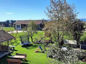 Un cortile residenziale con un trampolino, uno scivolo e un ponte in legno.