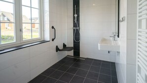 A bathroom with a window, a shower, and a sink. - Watervilla Miva Wellness 6 (Medemblik)