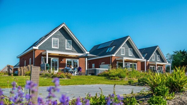 A residential building with a symmetrical design, featuring a central entrance and two side wings. - Watervilla Miva Wellness 6 (Medemblik)
