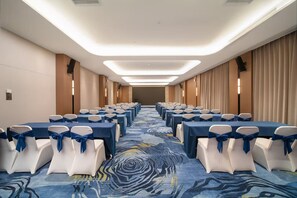 A hotel conference room with rows of tables, chairs, and a patterned carpet. - Wanda Moments Bengbu south Railway (Bengbu)