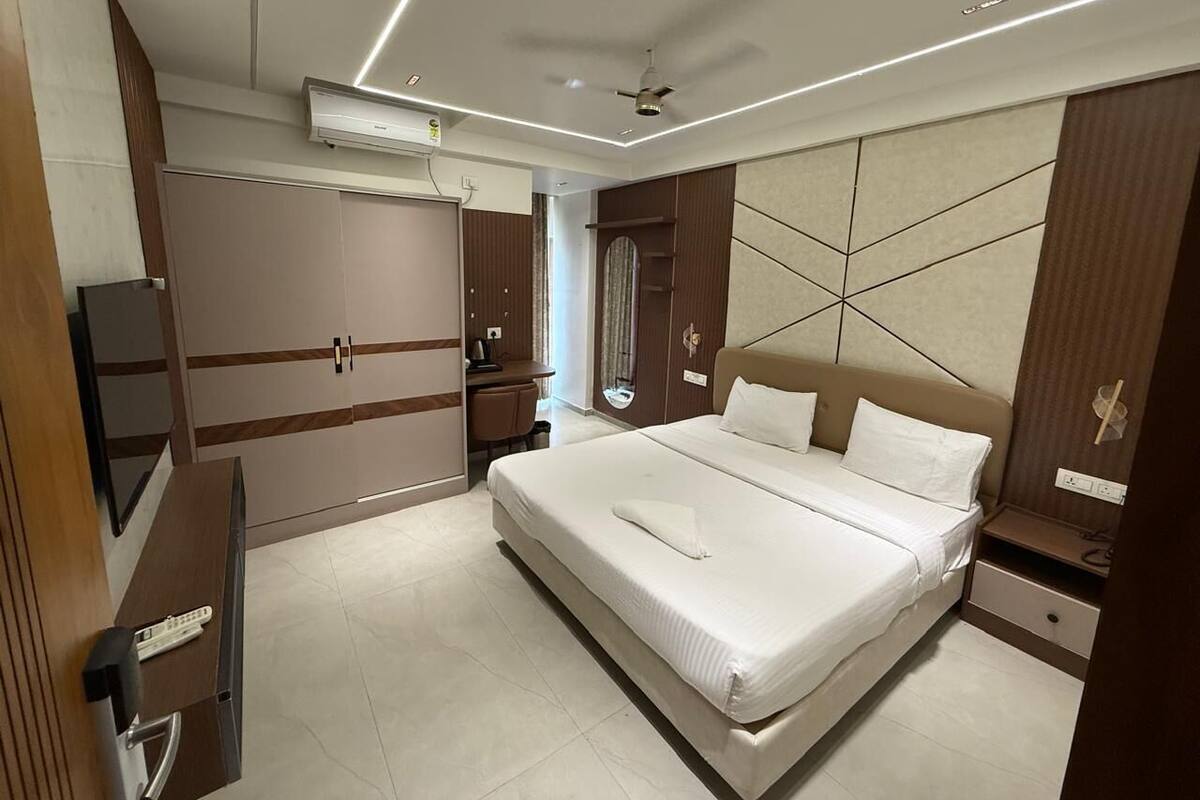 Une chambre d’hôtel moderne dotée d’un grand lit, d’une armoire intégrée, d’un bureau et d’un miroir.
